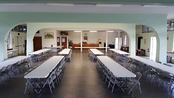 An empty and tidy social hall set with tables and chairs