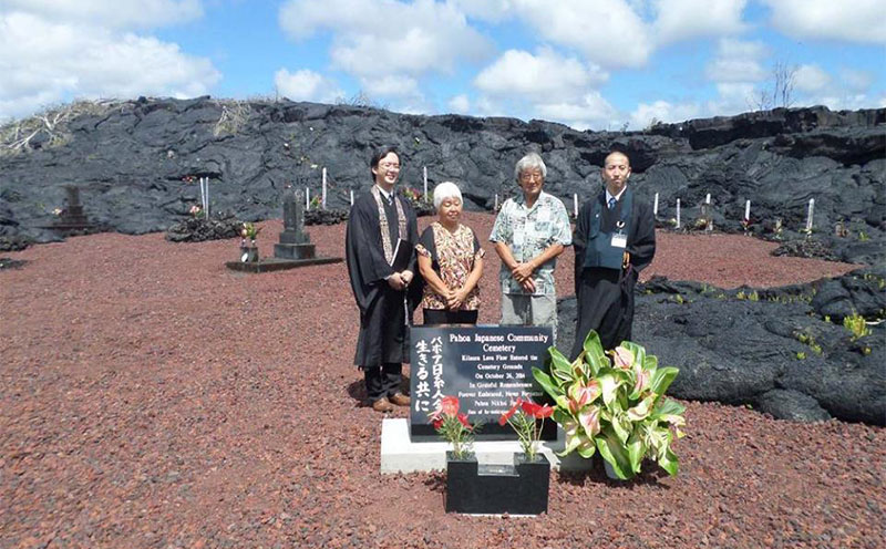 Ministers and attendees by newly dedicated memorial with lava flow in background
