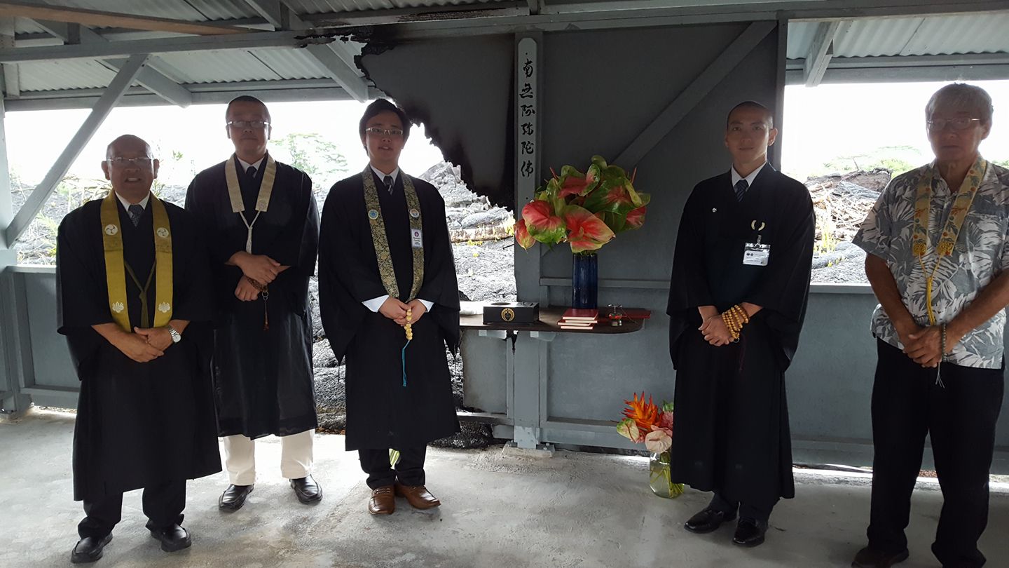 ministers with flower arrangement inside building damaged by lava flow